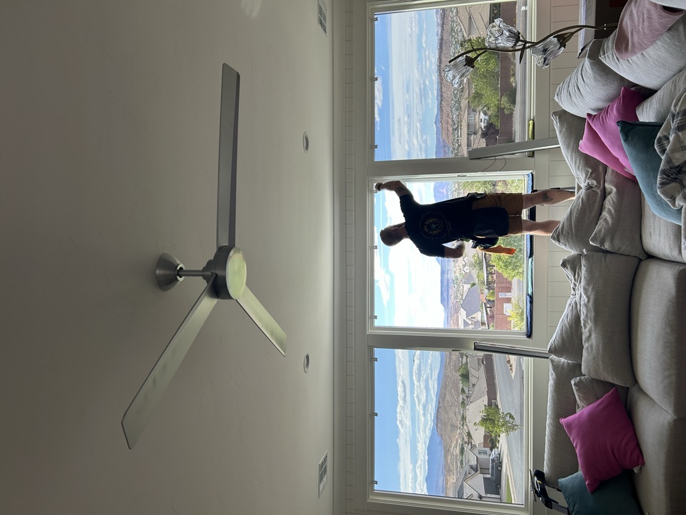 Imperial installer applying window film at a picture window with a valley view